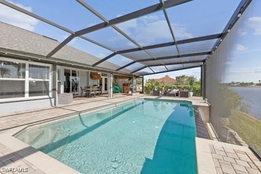 view of pool featuring a lanai, a patio area, and a water view