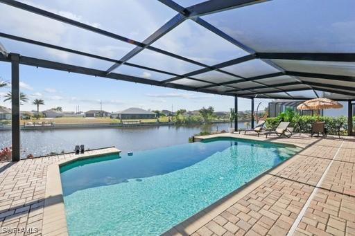 view of swimming pool featuring a patio, a water view, and a lanai