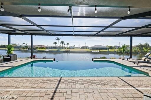 view of swimming pool featuring a water view, glass enclosure, and a patio area