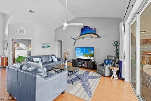 living room with ceiling fan, hardwood / wood-style floors, and lofted ceiling