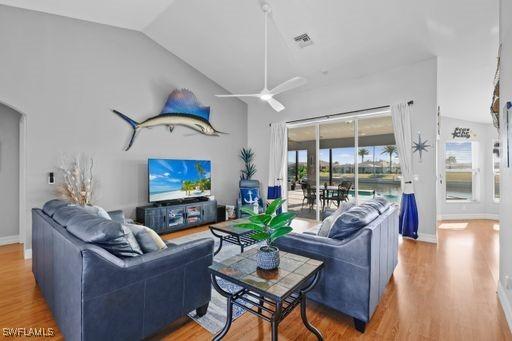 living room featuring hardwood / wood-style flooring, high vaulted ceiling, and ceiling fan