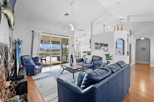 living room featuring ceiling fan, lofted ceiling, and light hardwood / wood-style flooring