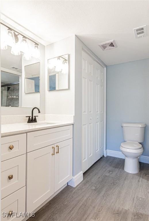 bathroom with vanity, hardwood / wood-style flooring, and toilet