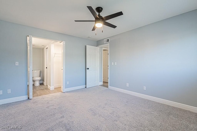 unfurnished bedroom with ceiling fan, light carpet, and ensuite bath