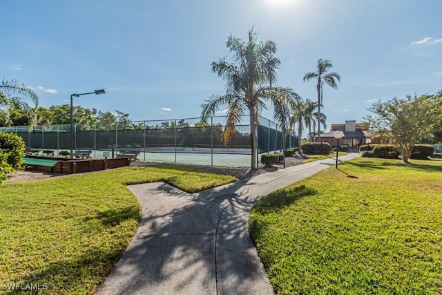 view of home's community with a yard and tennis court