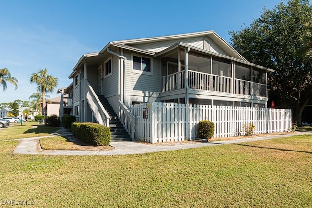 back of property with a yard and a sunroom