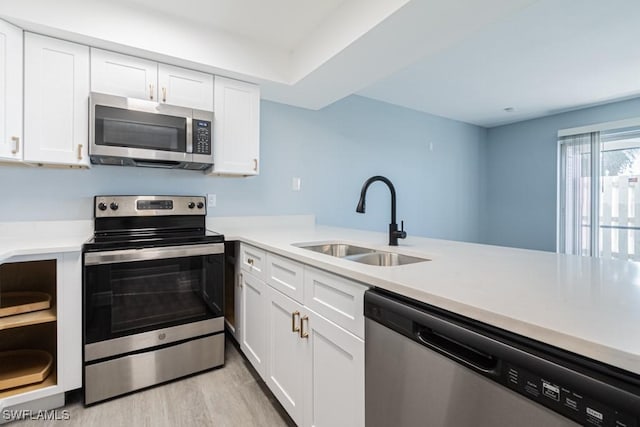 kitchen with white cabinets, appliances with stainless steel finishes, and sink