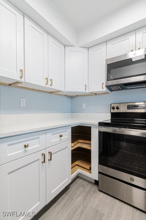 kitchen featuring white cabinetry, appliances with stainless steel finishes, and light hardwood / wood-style floors