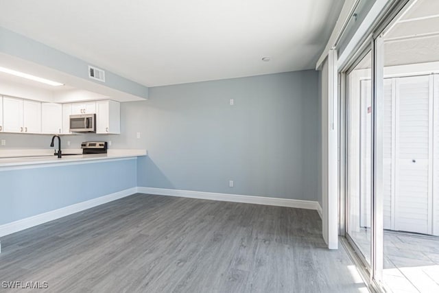 kitchen with white cabinetry, hardwood / wood-style flooring, and stainless steel appliances