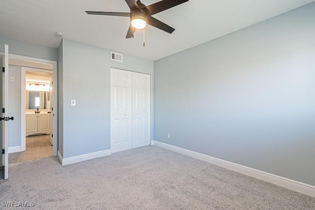 unfurnished bedroom with light carpet, a closet, and ceiling fan