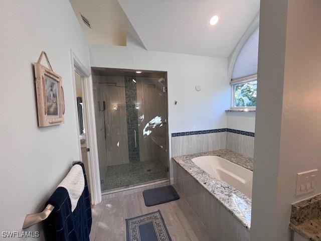 bathroom featuring separate shower and tub