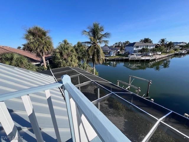 view of dock featuring a lanai and a water view