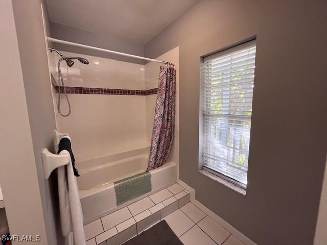 bathroom with tile patterned floors and shower / bath combo with shower curtain