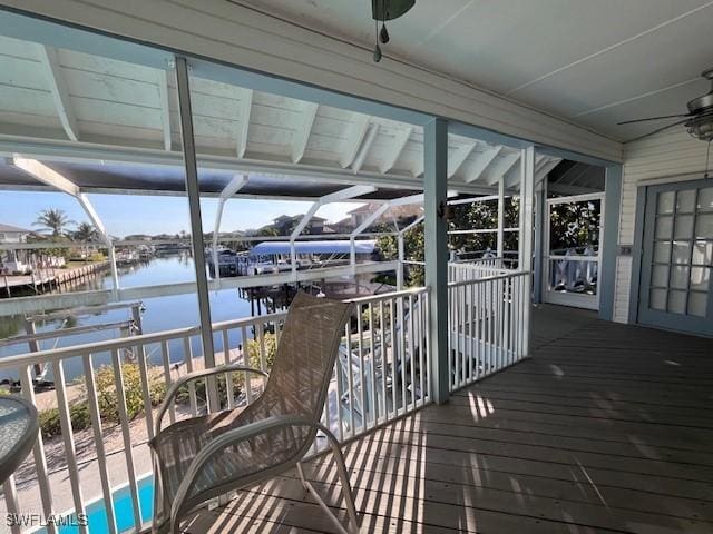 wooden terrace featuring a water view, a pool, ceiling fan, and a lanai