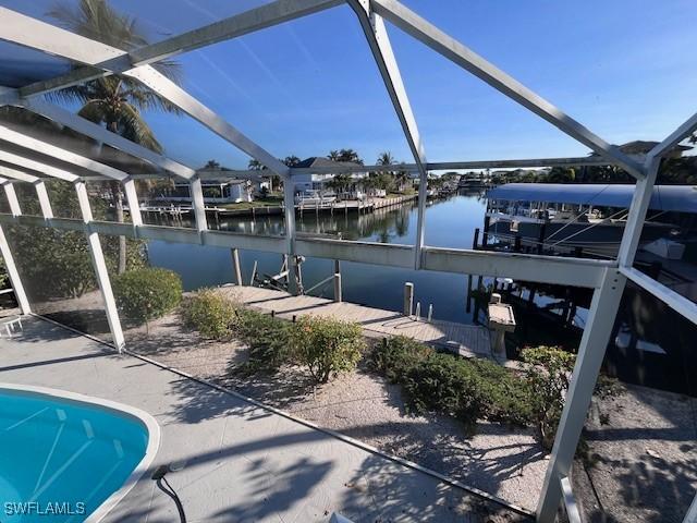 exterior space featuring a boat dock, a water view, and a lanai