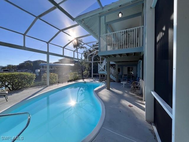 view of swimming pool featuring a patio and a lanai