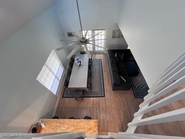 living room featuring ceiling fan, wood-type flooring, and a high ceiling