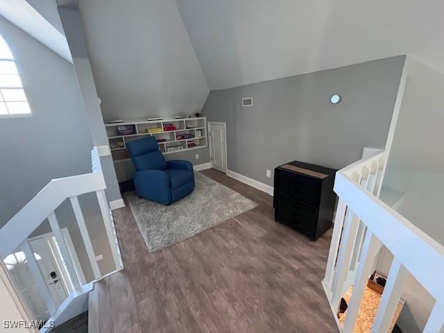 living area featuring vaulted ceiling and dark wood-type flooring