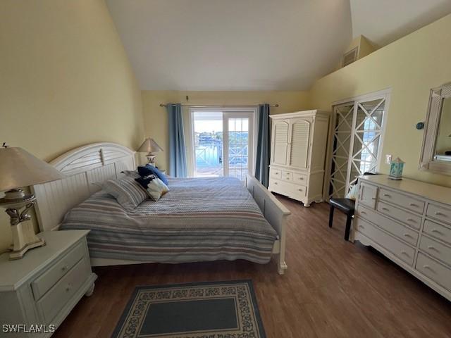 bedroom with dark hardwood / wood-style floors and lofted ceiling