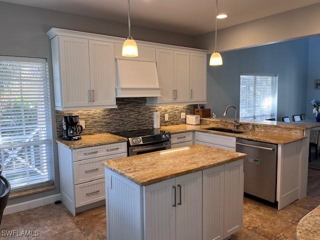 kitchen with a kitchen island, sink, kitchen peninsula, and stainless steel appliances