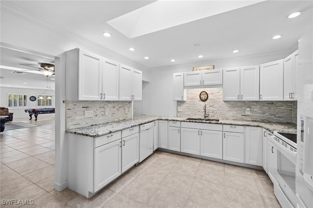 kitchen featuring white cabinets, stove, pool table, and sink