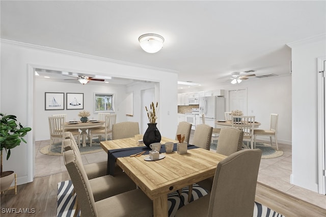 dining area featuring crown molding, ceiling fan, and light hardwood / wood-style floors