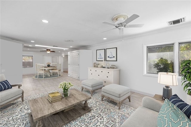 living room featuring light tile patterned floors, ceiling fan, and crown molding