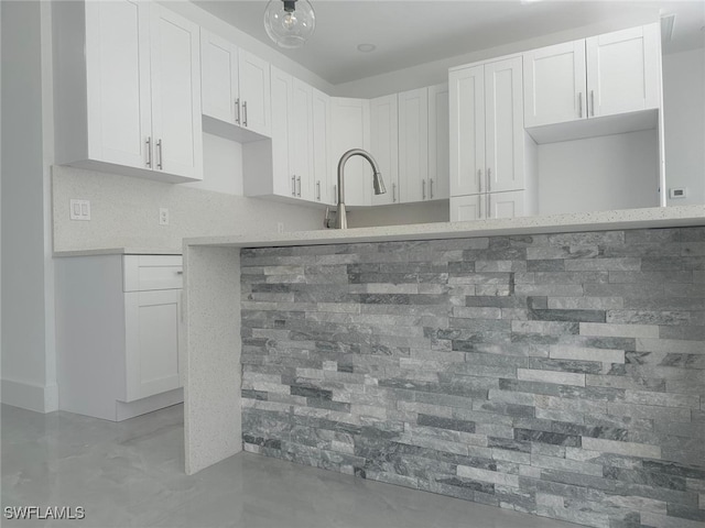 kitchen featuring tasteful backsplash, sink, and white cabinets