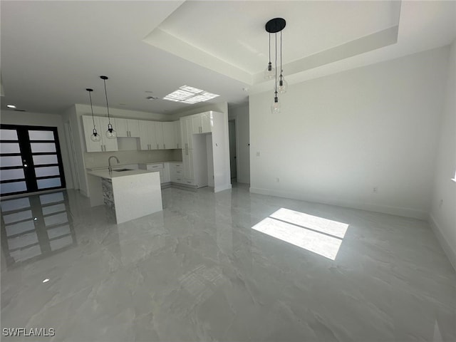 unfurnished living room with a raised ceiling and sink