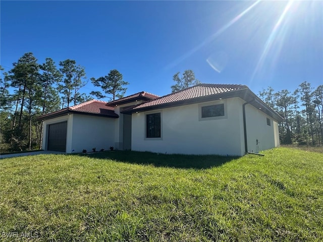 view of property exterior featuring a garage and a lawn