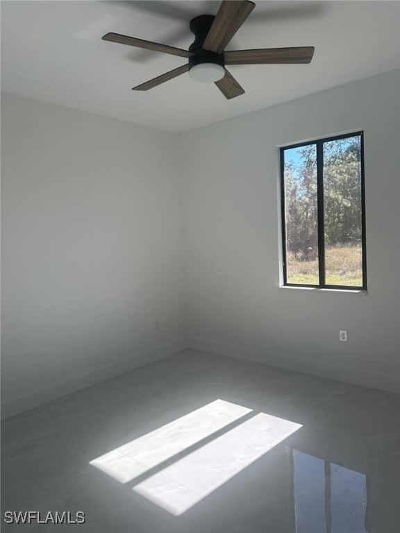 spare room featuring ceiling fan and concrete floors