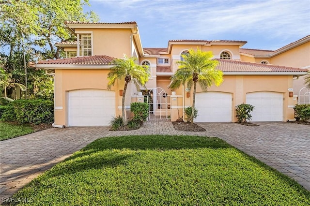 mediterranean / spanish house featuring a garage and a front lawn