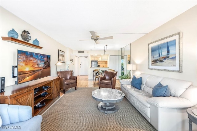 living room featuring ceiling fan and wood-type flooring