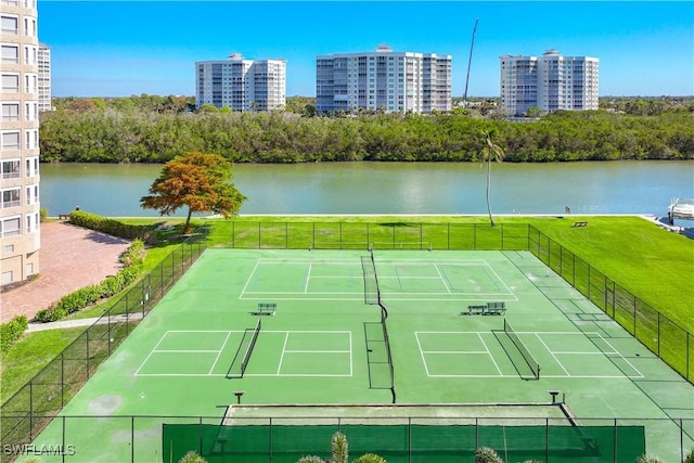 view of tennis court featuring a yard and a water view