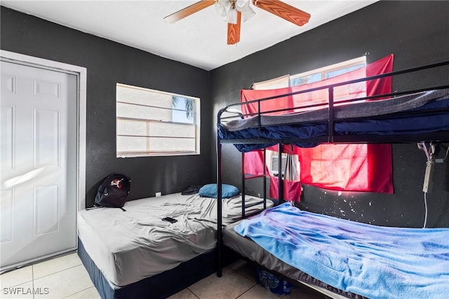 tiled bedroom featuring ceiling fan