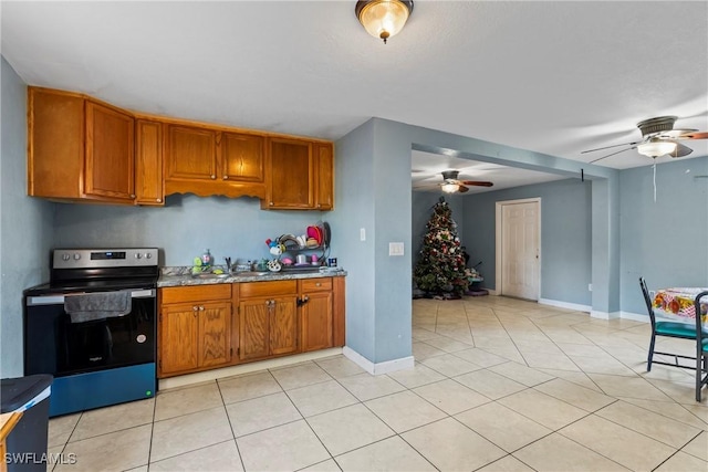 kitchen with light tile patterned floors, ceiling fan, stainless steel range with electric stovetop, and sink