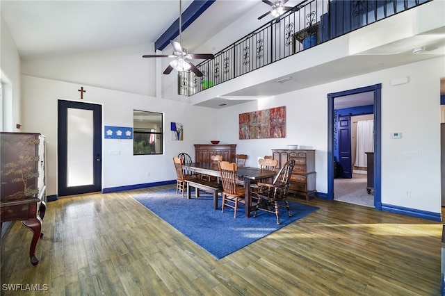 dining space with high vaulted ceiling, a ceiling fan, baseboards, and wood finished floors