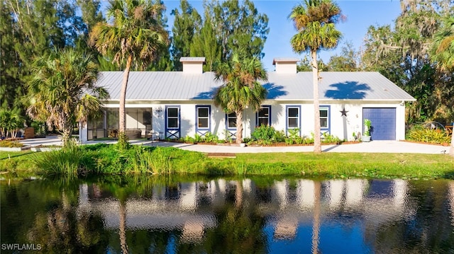 view of front of home with a water view and a garage