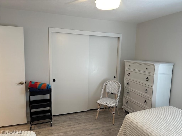 bedroom with light hardwood / wood-style floors and a closet