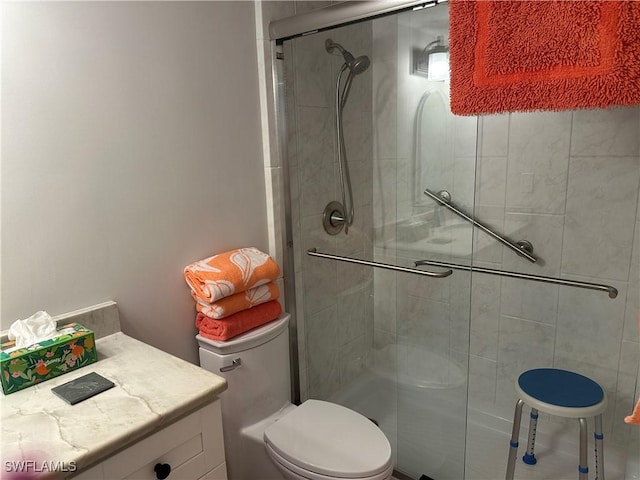 bathroom with vanity, toilet, and a shower with door