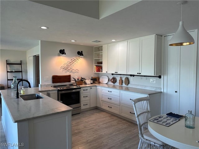 kitchen featuring kitchen peninsula, sink, pendant lighting, white cabinets, and stainless steel range with electric cooktop