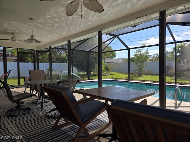 view of pool with ceiling fan, glass enclosure, and a patio