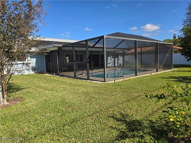 rear view of house featuring a yard, glass enclosure, and a patio area