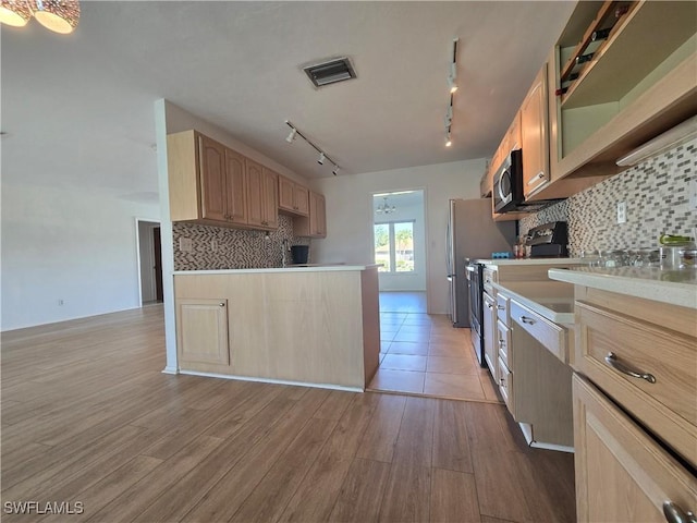 kitchen with light hardwood / wood-style flooring, light brown cabinetry, and decorative backsplash