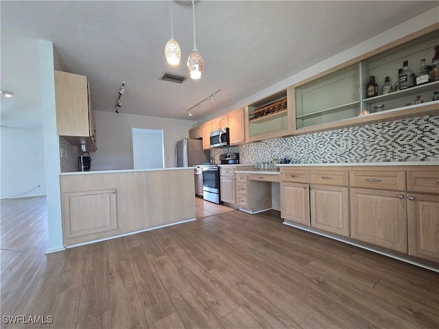 kitchen with appliances with stainless steel finishes, hardwood / wood-style floors, tasteful backsplash, light brown cabinetry, and decorative light fixtures