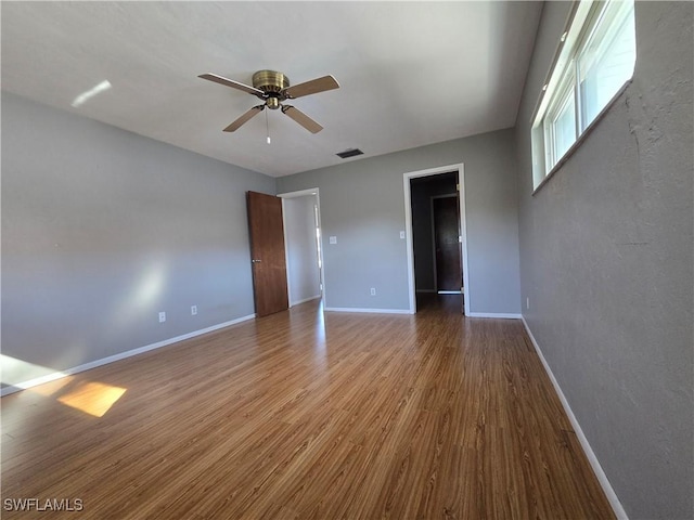 empty room with hardwood / wood-style flooring and ceiling fan