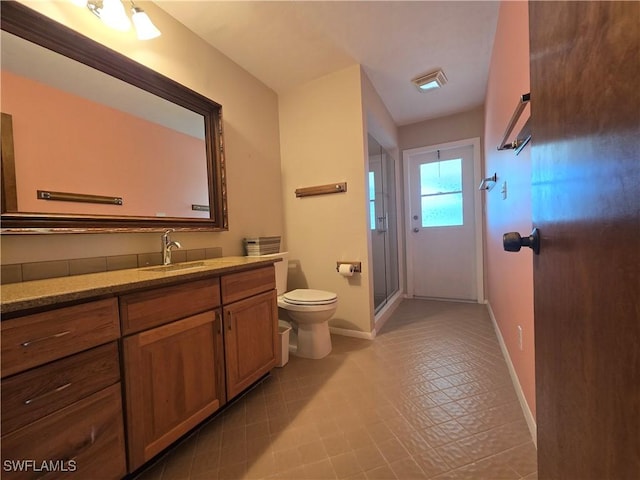 bathroom with vanity, a shower with shower door, tile patterned floors, and toilet