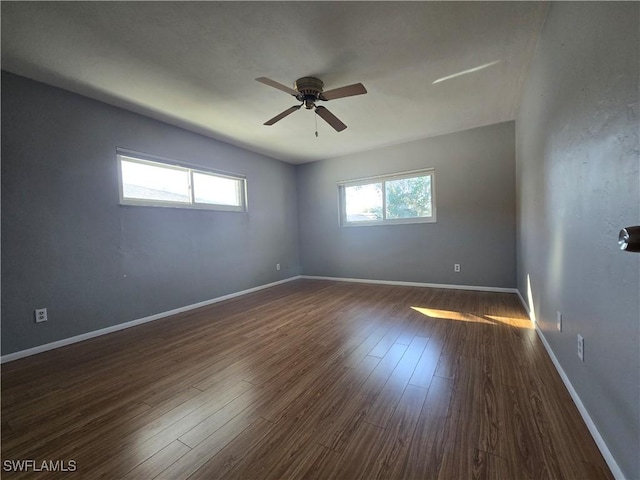 spare room featuring dark wood-type flooring and ceiling fan