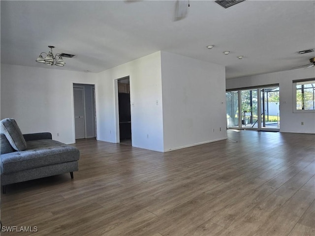 living room featuring ceiling fan with notable chandelier and hardwood / wood-style floors