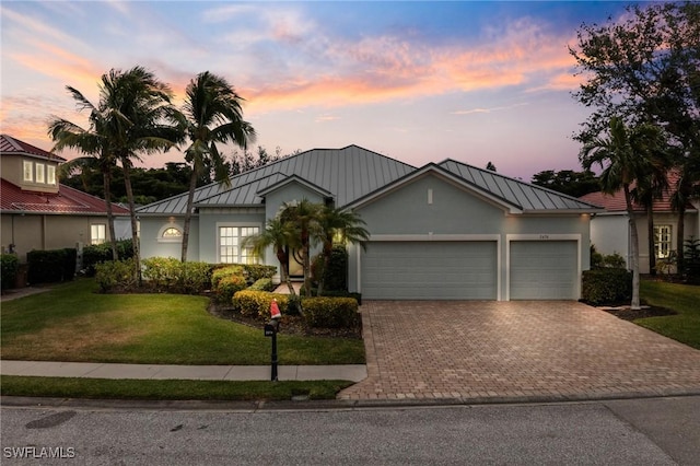 view of front of home featuring a lawn and a garage